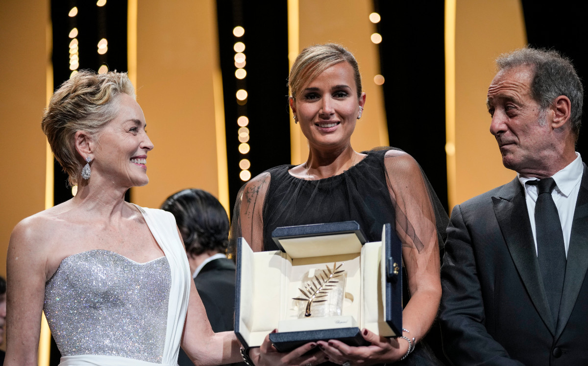 La directora Julia Ducournau, en el centro, posa con Sharon Stone y Vincent Lindon tras ganar la Palma de Oro por la película "Titane" en la ceremonia de clausura del Festival Internacional de Cine de Cannes, el sábado 17 de julio de 2021 en Cannes, Francia. (AP Foto/Vadim Ghirda)