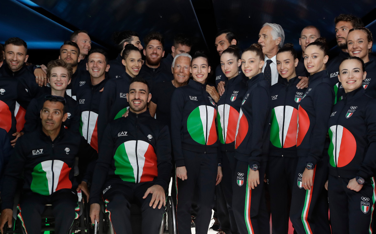 En esta fotografía de archivo del 15 de junio de 2019 el diseñador Giorgio Armani, centro, posa con atletas olímpicos italianos al final del desfile de la colección para caballeros primavera-verano 2020 en la Semana de la Moda de Milán, Italia. Emporio Armani creó el uniforme de la delegación olímpica italiana con una reinterpretación del sol naciente japonés en los colores de la bandera italiana. Los Juegos Olímpicos de Tokio se inauguran el 23 de julio, cuando los deportistas del mundo marcharán detrás de sus abanderados. Y cuando lo hagan, la gente también empezará a comentar sobre lo que llevan puesto. (Foto AP/Luca Bruno, archivo)